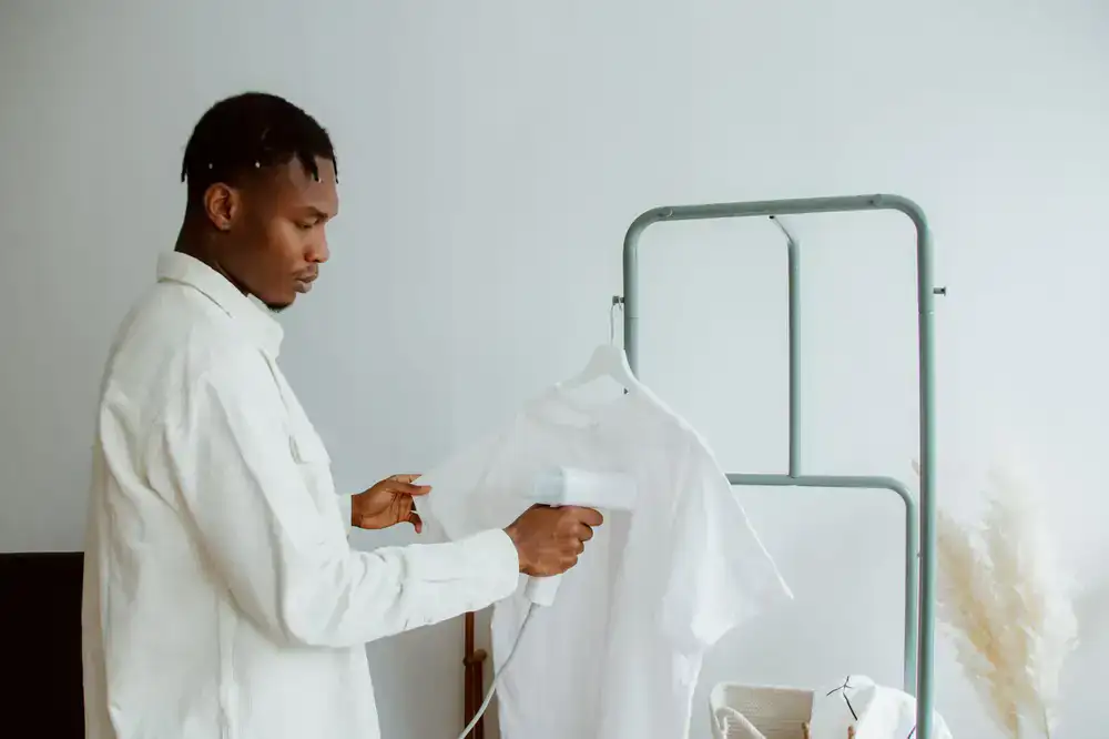 Crisp & Clean delivery driver handing freshly pressed shirts on hangers to a customer