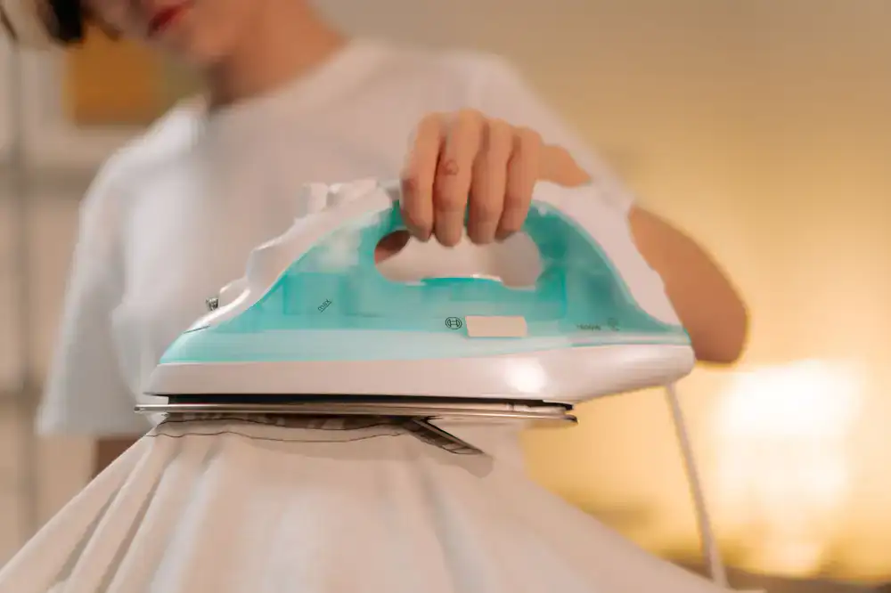 A professional meticulously steaming and pressing a dark suit jacket