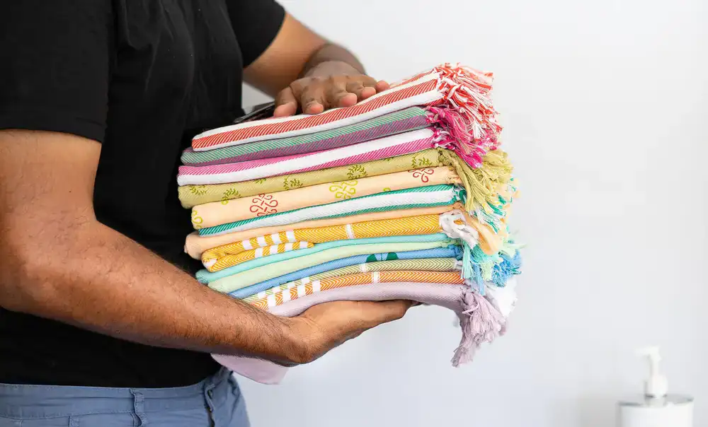 A stack of freshly washed, perfectly folded colorful towels and t-shirts